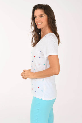Side shot of model wearing a white tee with multi color stars