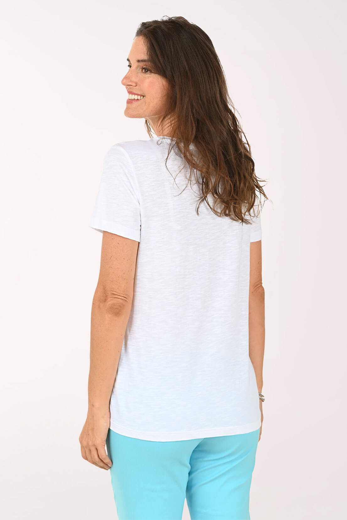 Back shot of model wearing a white tee with multi color stars
