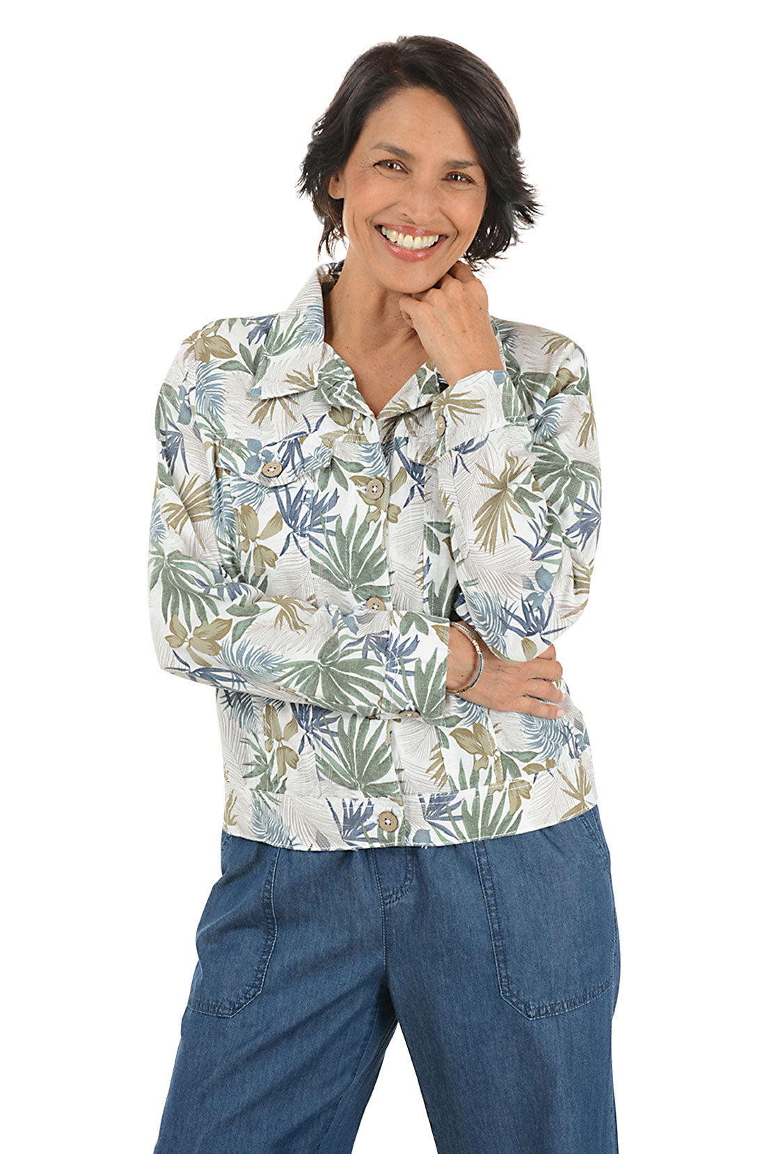 Woman wearing a floral patterned jacket and blue pants on a white background.