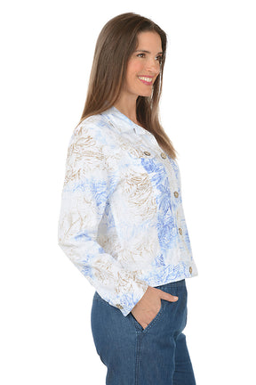 Woman wearing a floral button-up shirt and blue pants on a white background