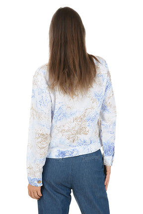 Woman wearing a floral button-up shirt and blue pants on a white background