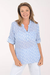 Woman wearing a light blue patterned shirt on a white background