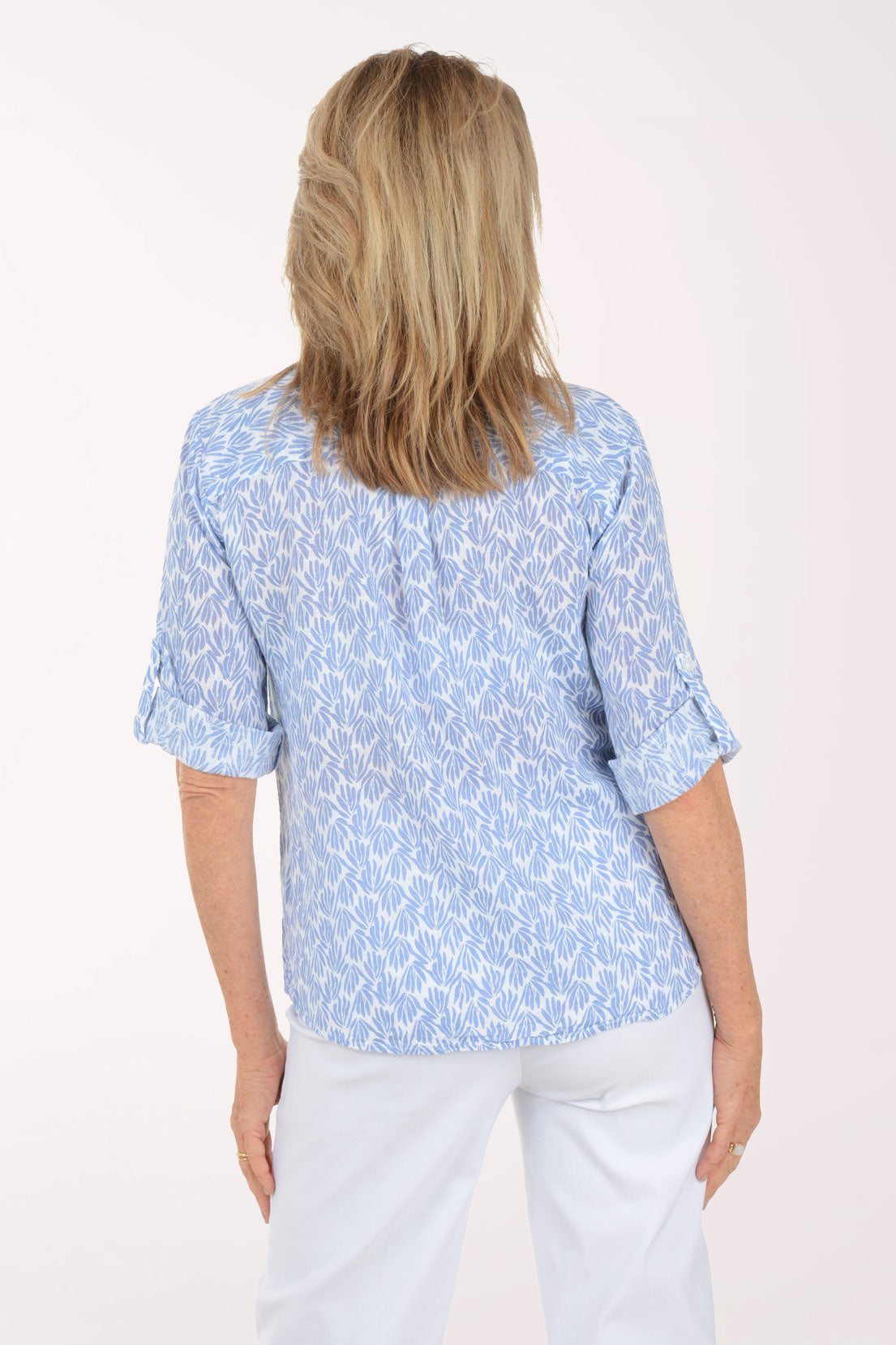 Woman wearing a light blue patterned shirt on a white background