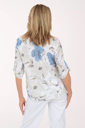 Woman wearing a floral blouse with blue flowers on a white background