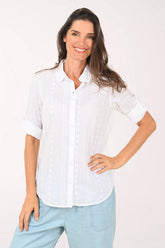 Woman wearing a white roll sleeve top.