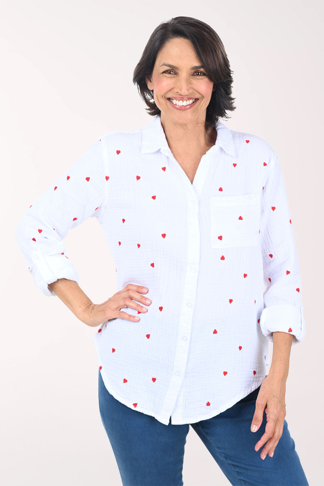 Woman wearing a white button down shirt with embroidered hearts