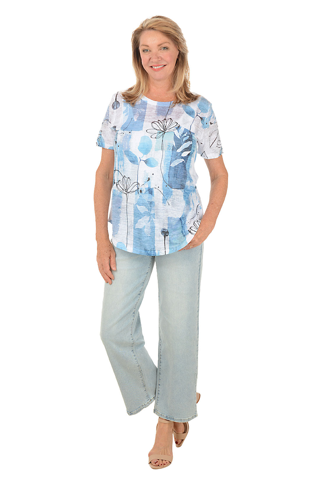Woman wearing a blue floral blouse and light blue jeans on a white background