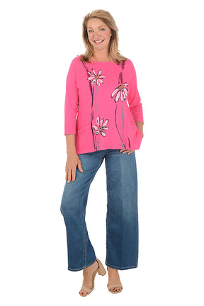 Woman wearing a pink floral top and blue jeans on a white background