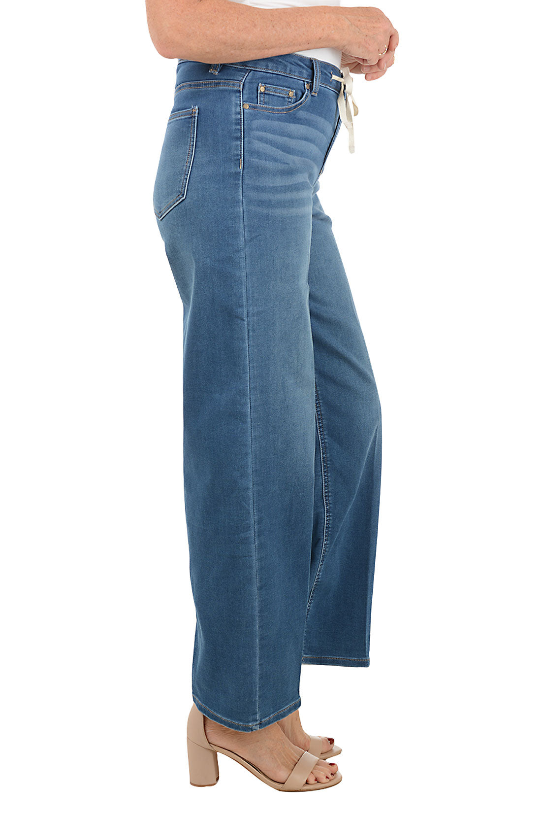 Blue jeans with a drawstring waist on a white background. Side shot.