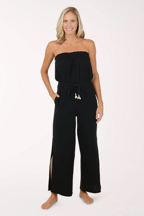 Woman wearing a black strapless jumpsuit on a white background