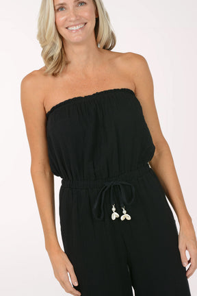 Woman wearing a black strapless jumpsuit on a white background