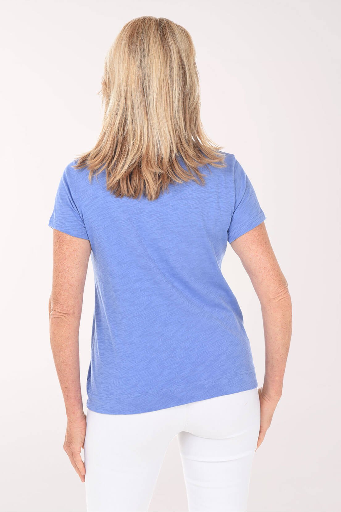 Woman wearing a blue t-shirt on a white background. Back shot.