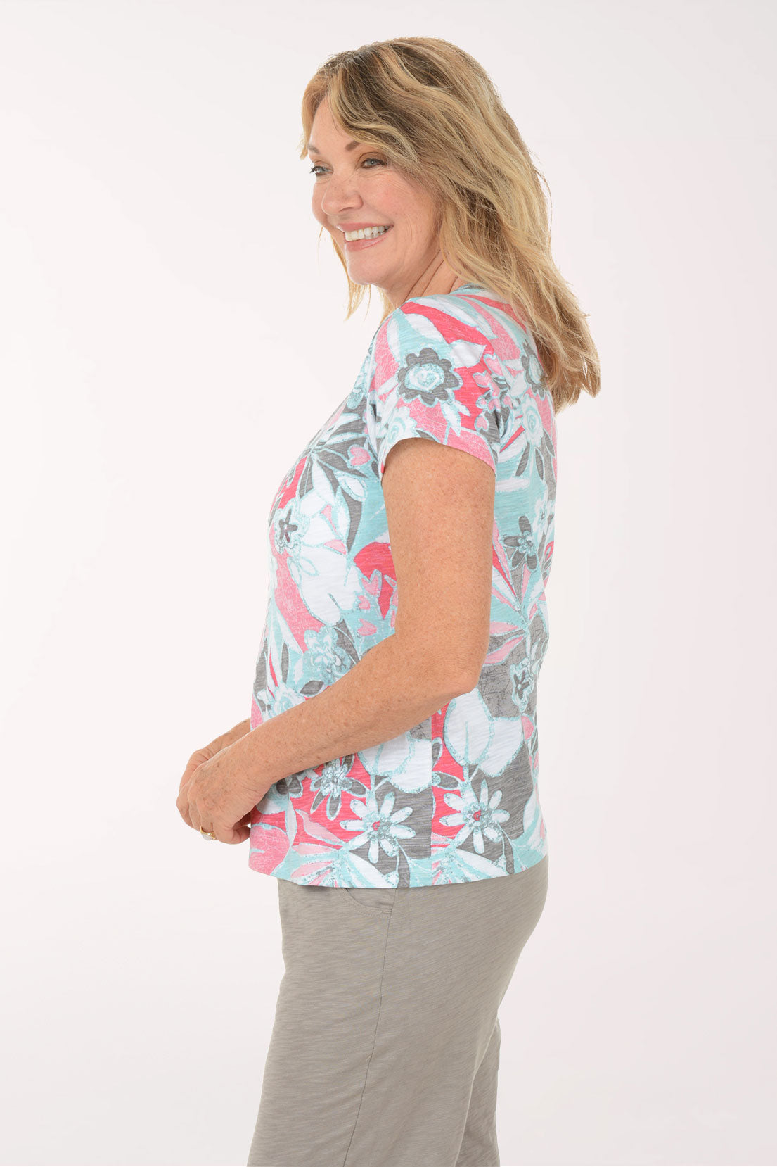 A woman wearing a short sleeve multicolored floral top.