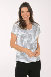 A woman wearing a short sleeve grey and white top.