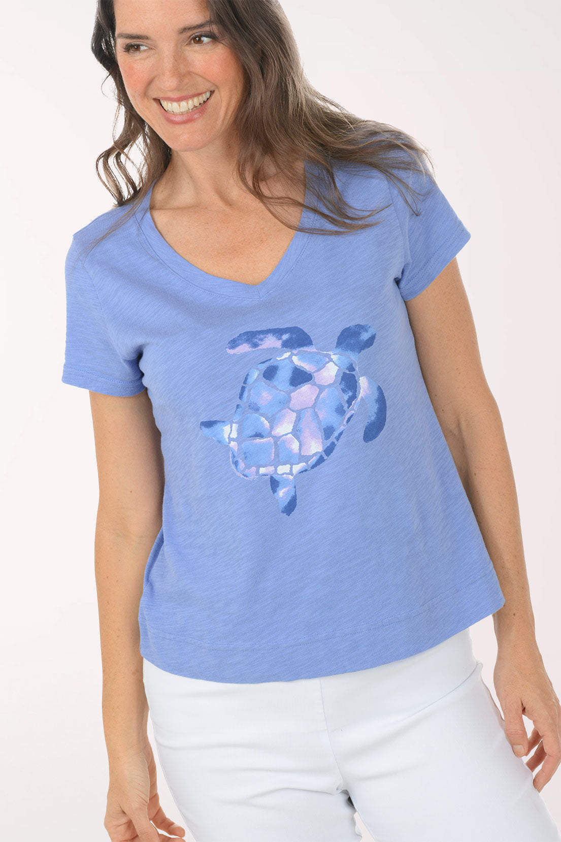 A woman wearing a short sleeve blue top with a turtle print.