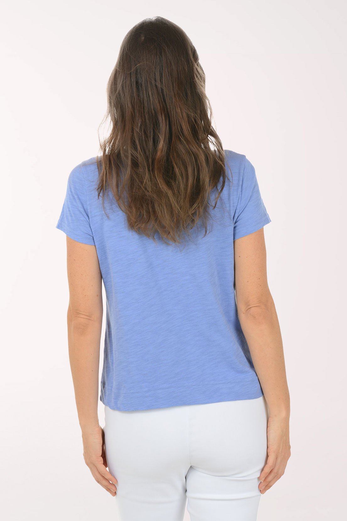 A woman wearing a short sleeve blue top with a turtle print.