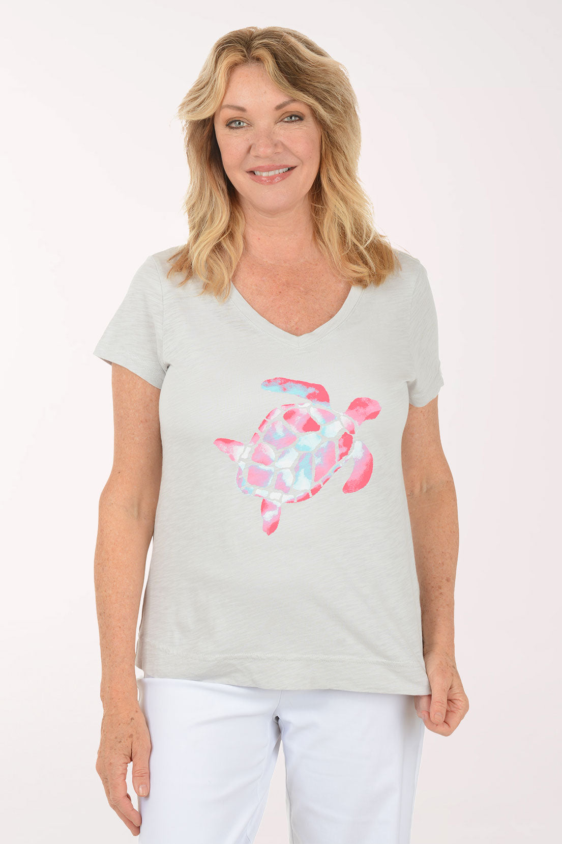 A woman wearing a short sleeve grey top with a turtle print.