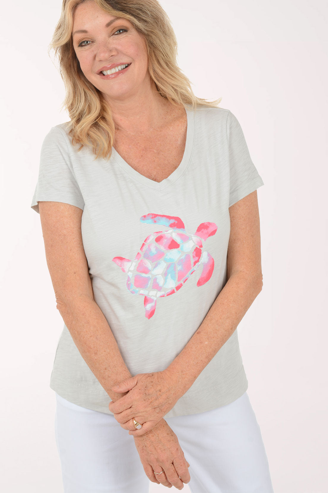 A woman wearing a short sleeve grey top with a turtle print.