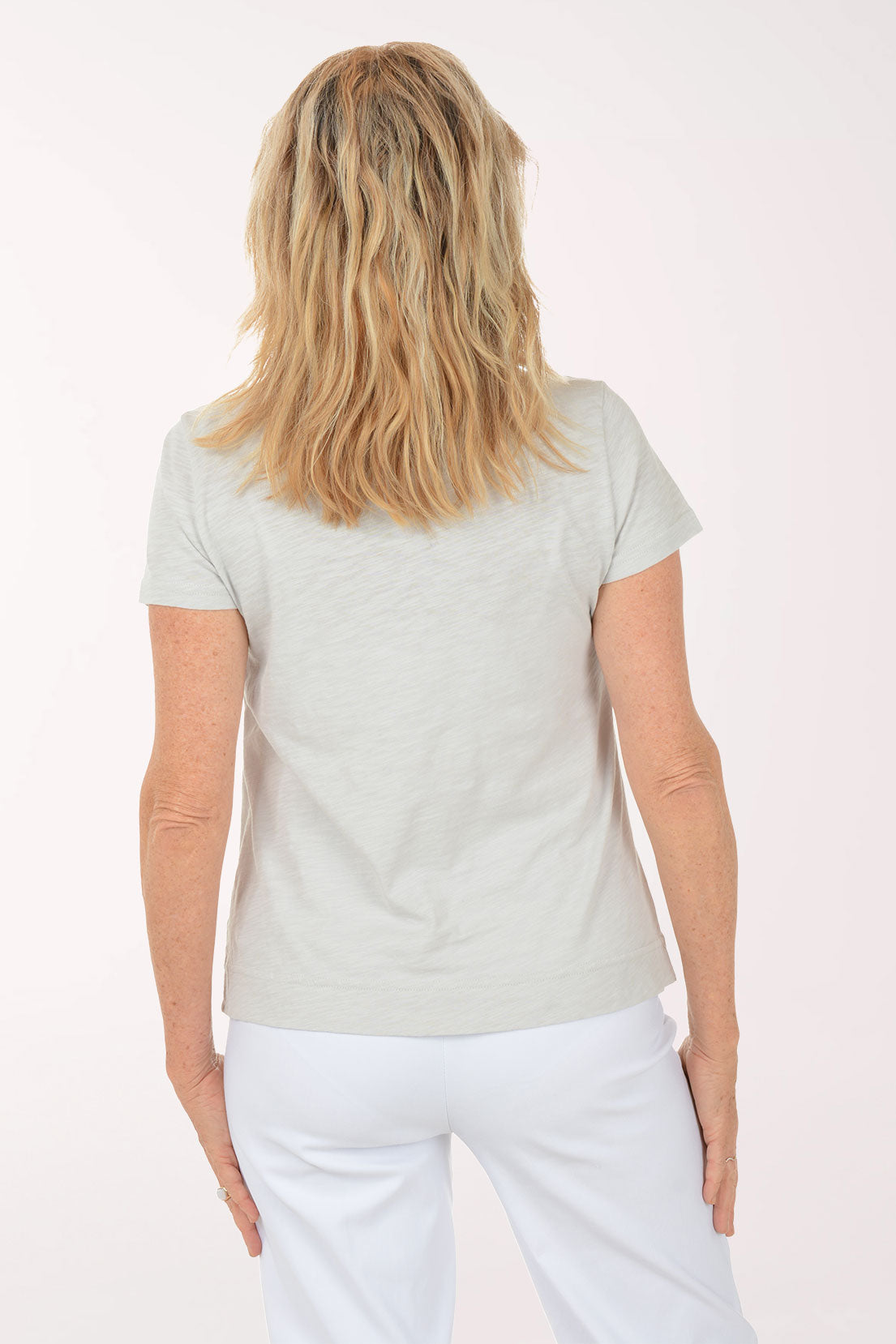 A woman wearing a short sleeve grey top with a turtle print.