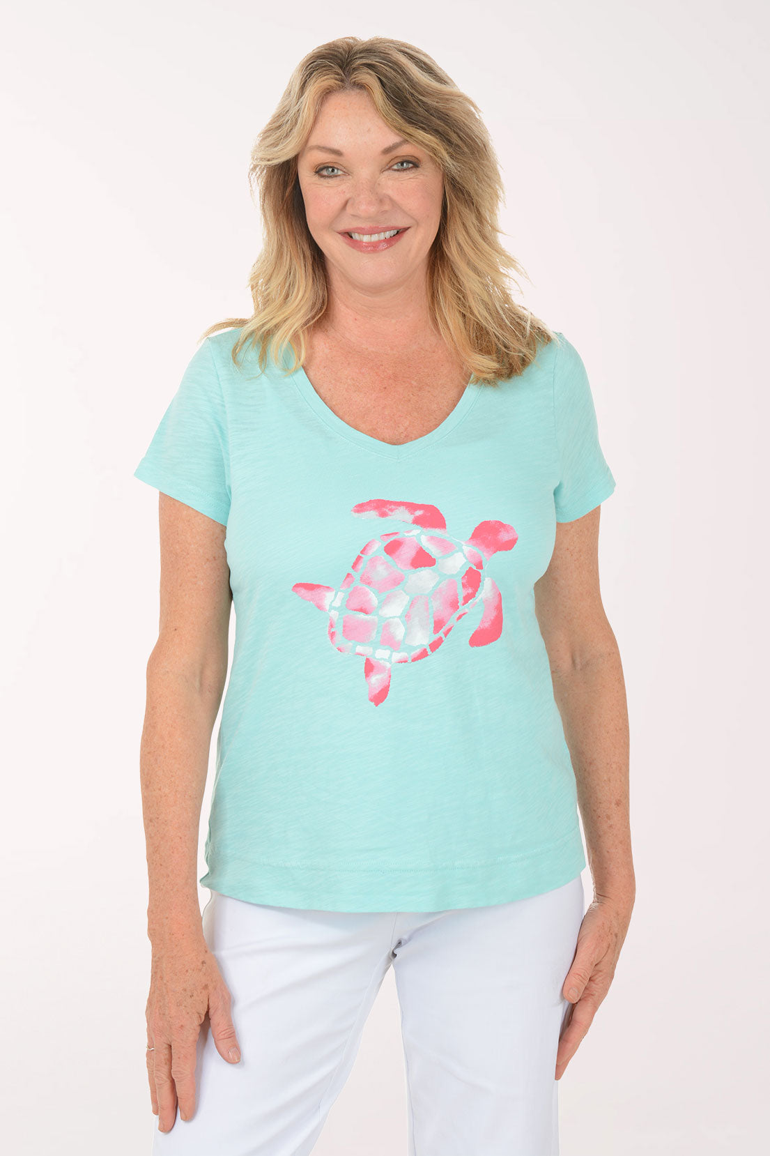 A woman wearing a short sleeve blue top with a turtle print.