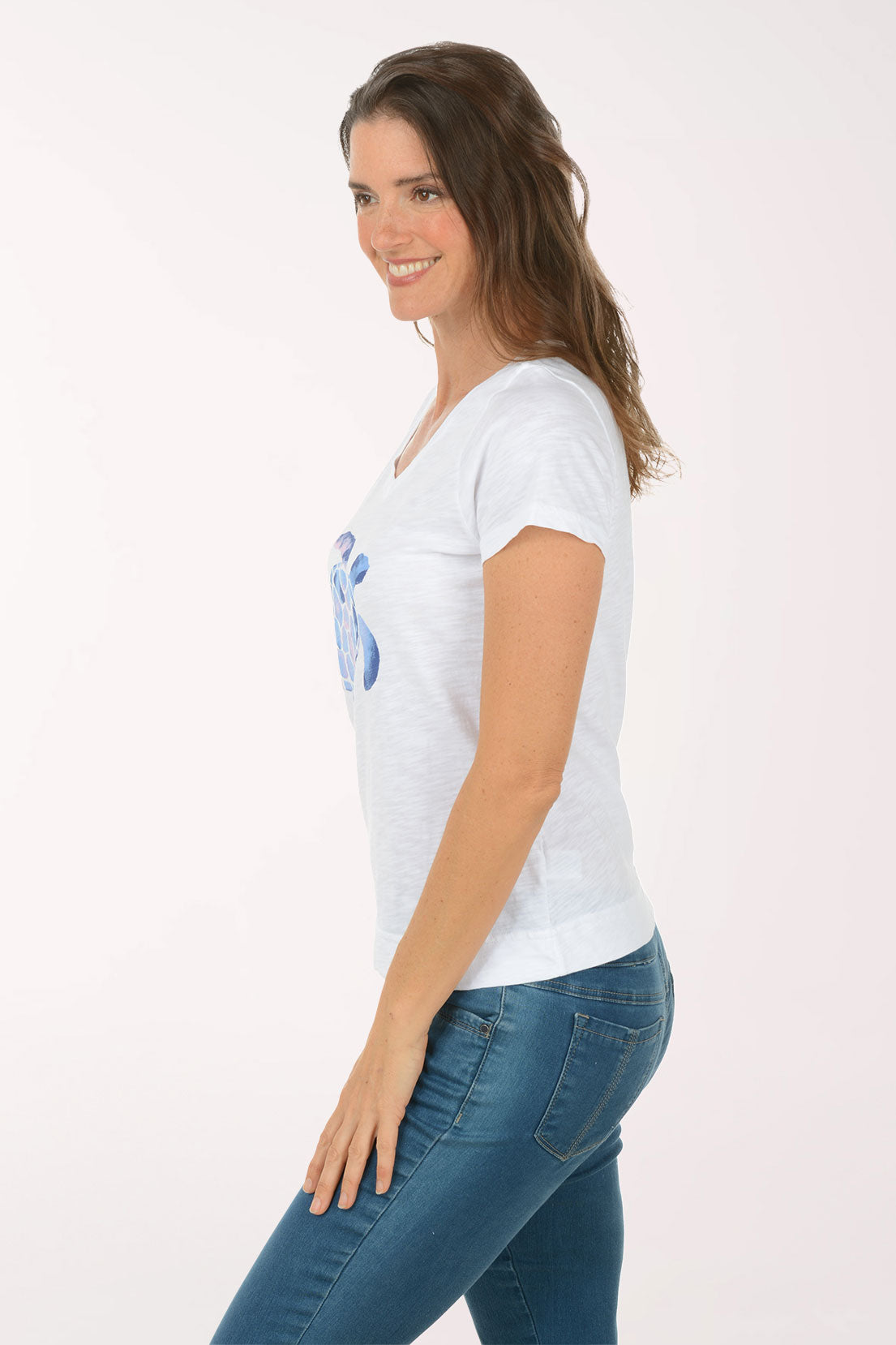 A woman wearing a short sleeve white top with a turtle print.