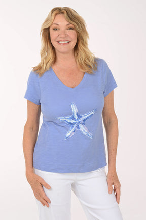 A woman wearing a short sleeve blue top.