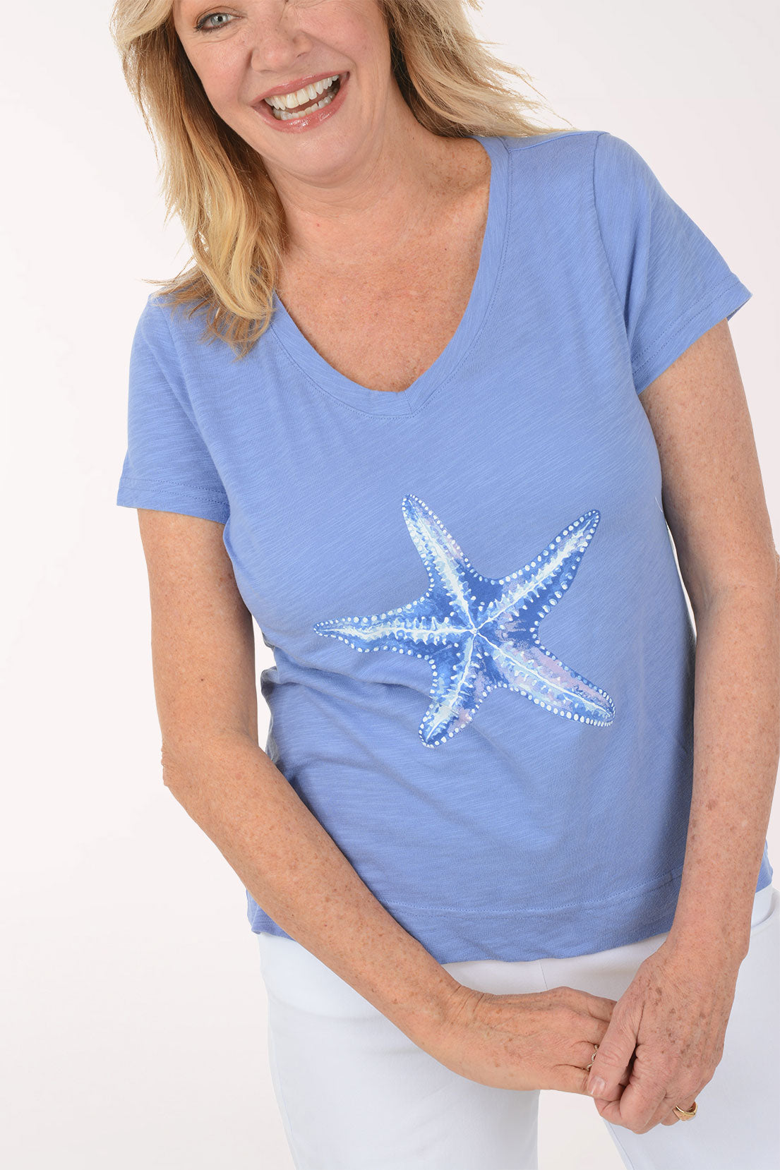 A woman wearing a short sleeve blue top.