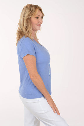 A woman wearing a short sleeve blue top.