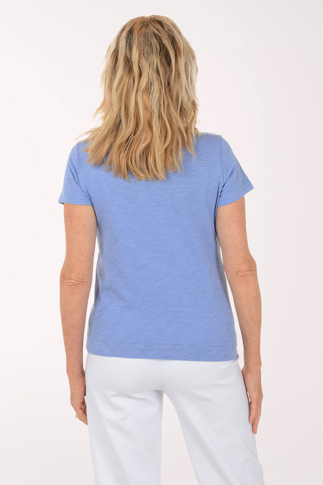 A woman wearing a short sleeve blue top.