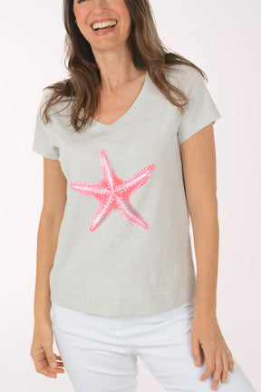 A woman wearing a short sleeve grey top.