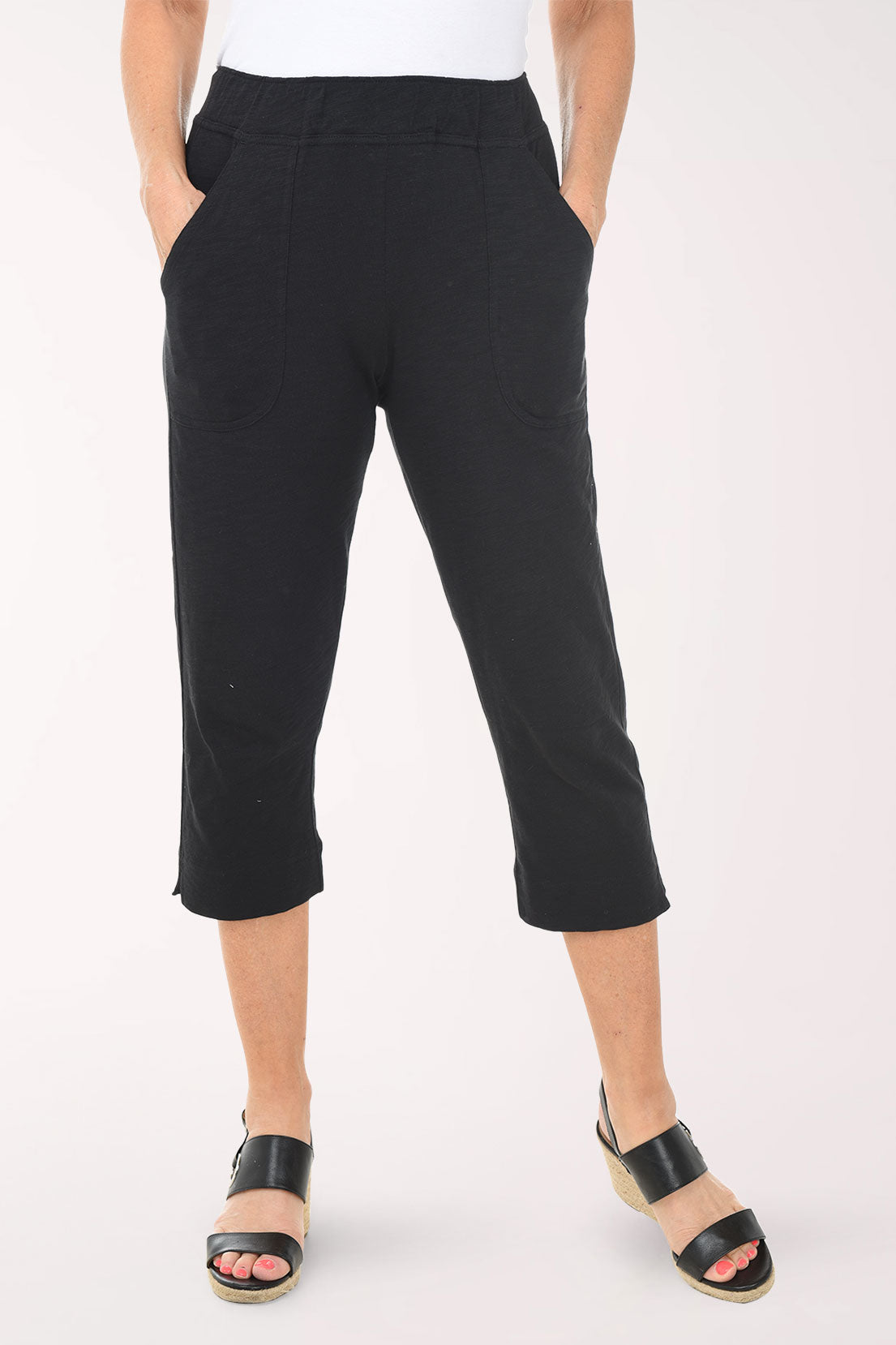 Person wearing black capri pants on a white background