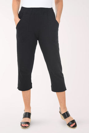 Person wearing black capri pants on a white background