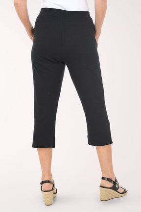 Person wearing black capri pants on a white background