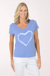 Woman wearing a blue t-shirt with a white heart design on a white background