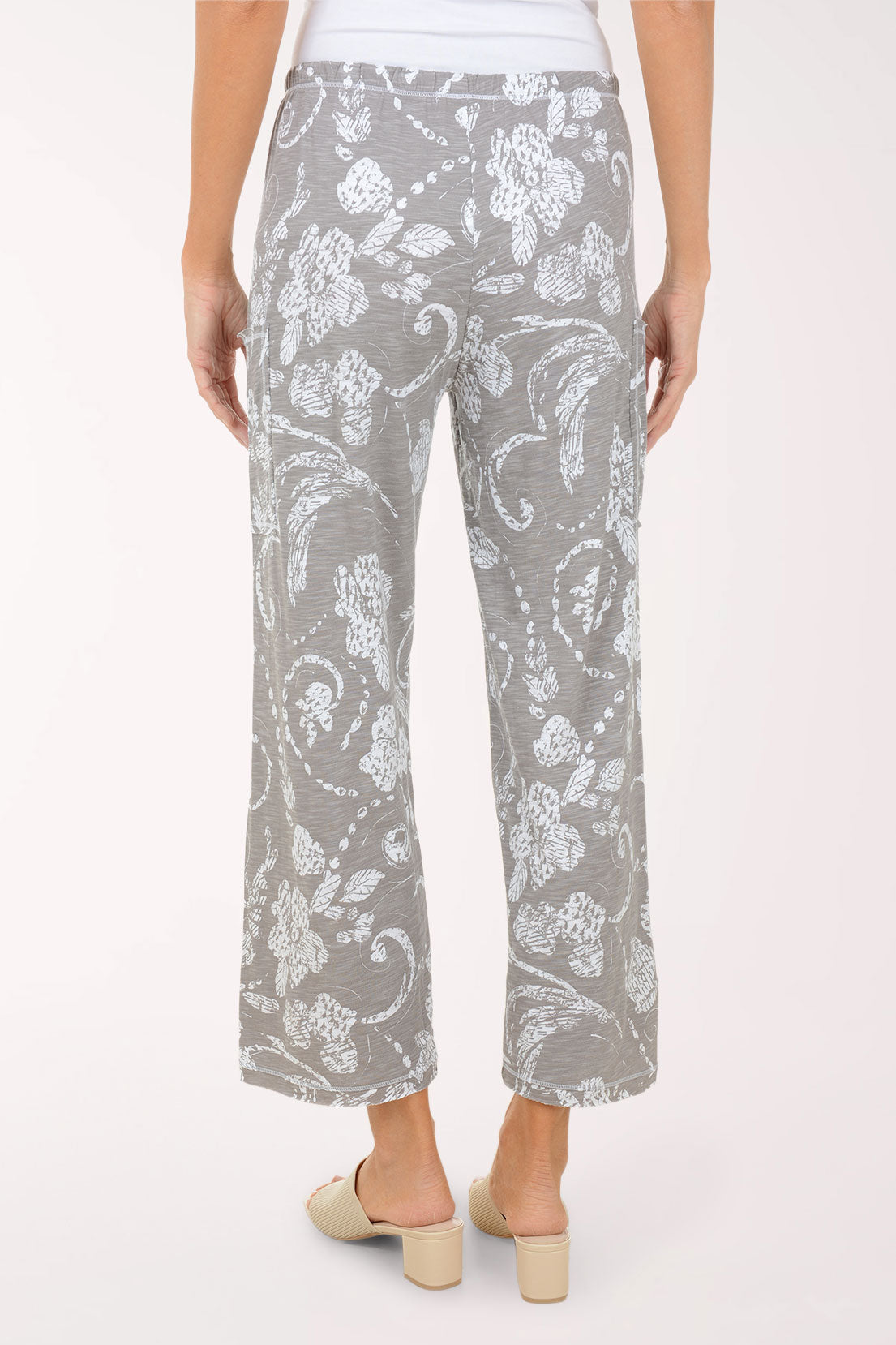 Gray floral-patterned pants worn by a person on a white background