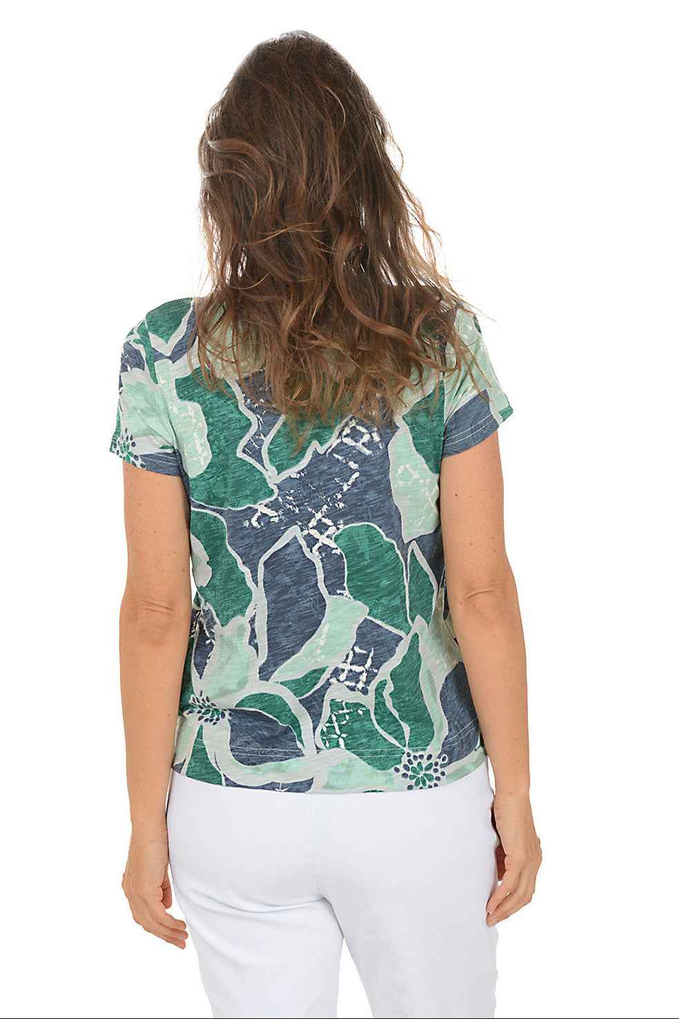 Woman wearing a patterned shirt with a white background. Back shot.