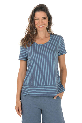 Woman wearing a blue striped shirt and pants on a white background.