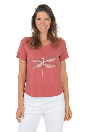 Woman wearing a red t-shirt with a dragonfly design on a white background.