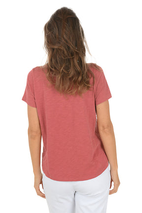 Woman wearing a red t-shirt with a dragonfly design on a white background. Back shot.