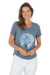 Woman wearing a blue t-shirt with a floral design on a white background.