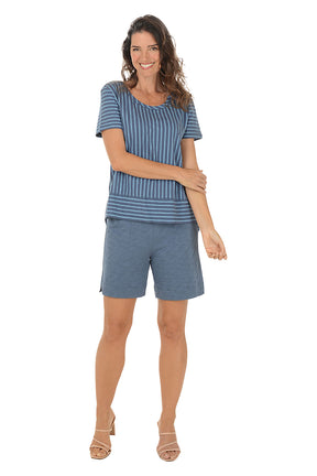 Woman wearing a blue striped top and shorts on a white background.