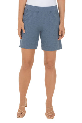 Blue shorts worn by a person on a white background.