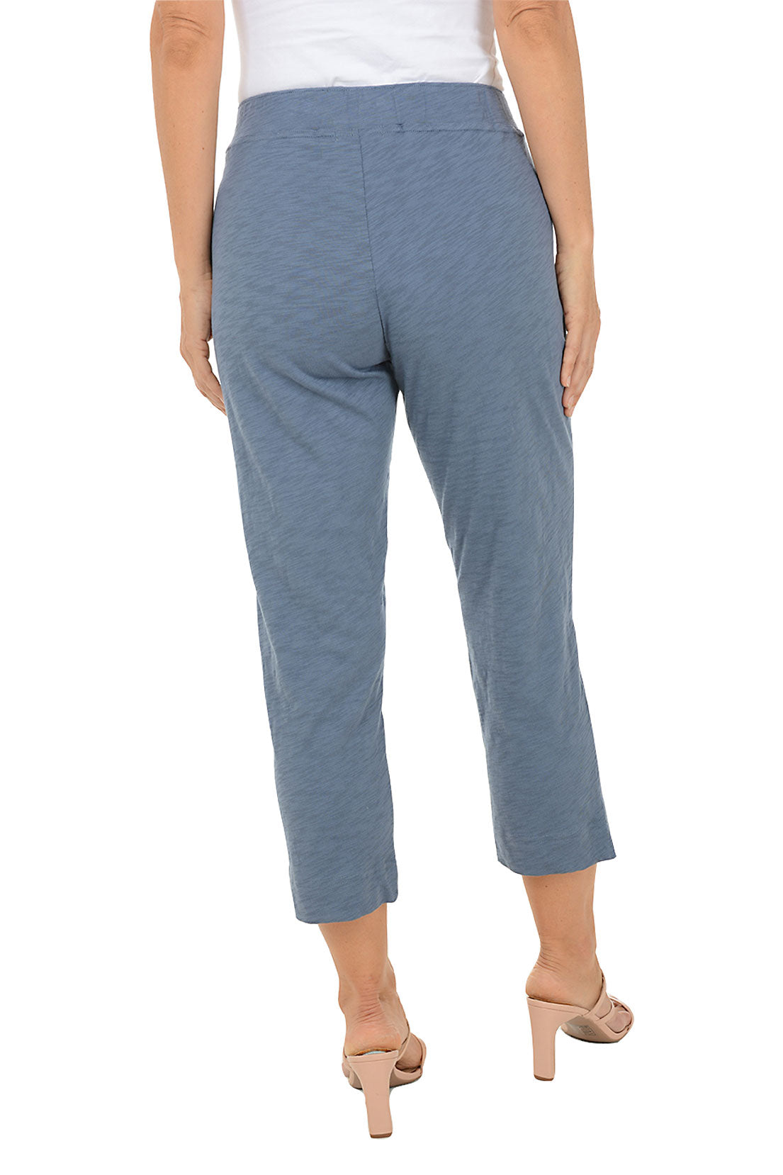 Blue capris worn by a person on a white background. Back shot.