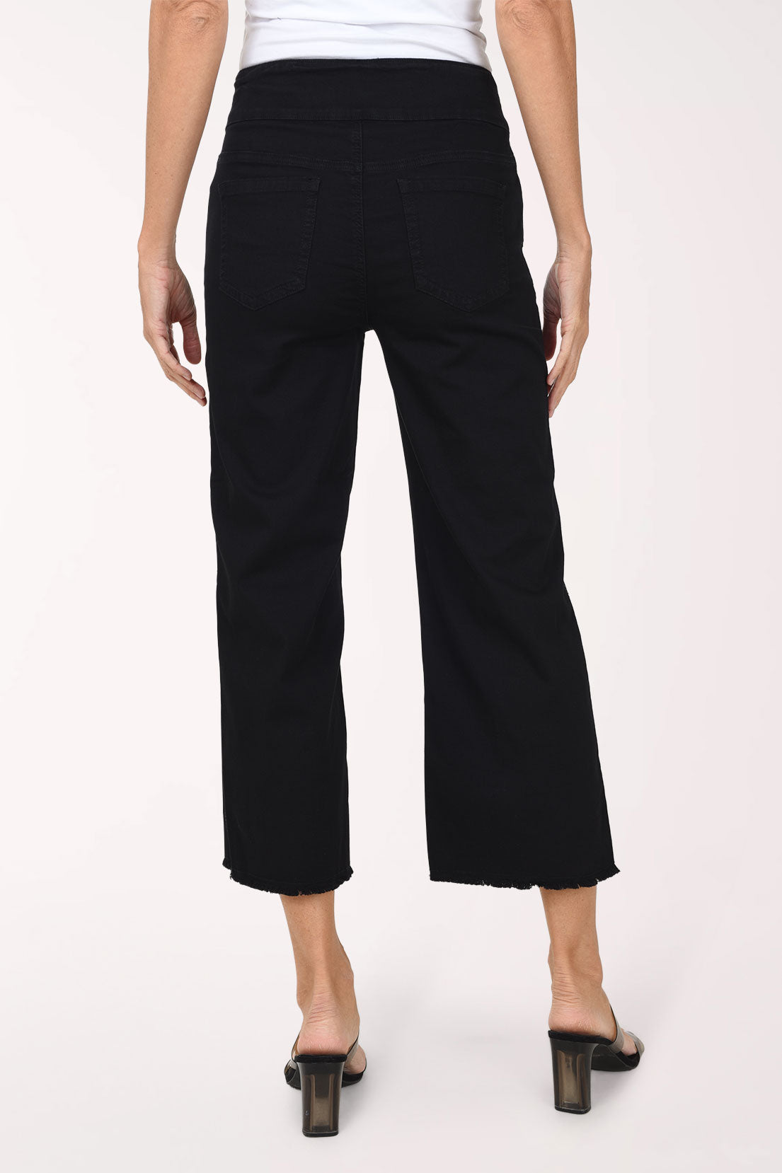 A back view of black wide-leg denim pants showing the back pockets, vertical rhinestone stripes and frayed hem.