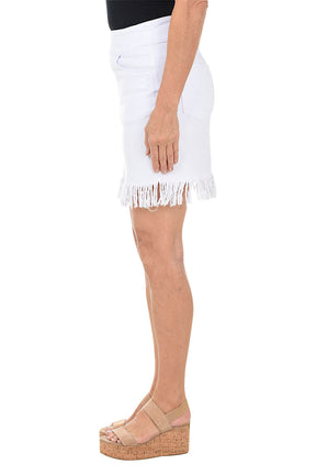 White skirt with fringe hem worn by a person on a white background. Side shot.