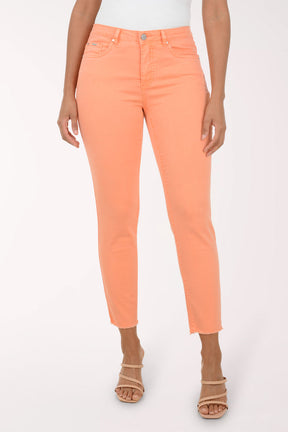 Woman wearing a patterned blouse and orange pants on a white background