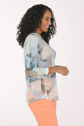 Woman wearing a patterned blouse and orange pants on a white background