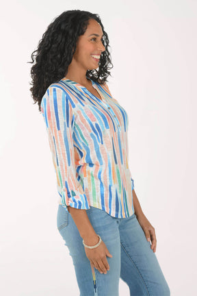 Woman wearing a colorful striped shirt and blue jeans on a white background