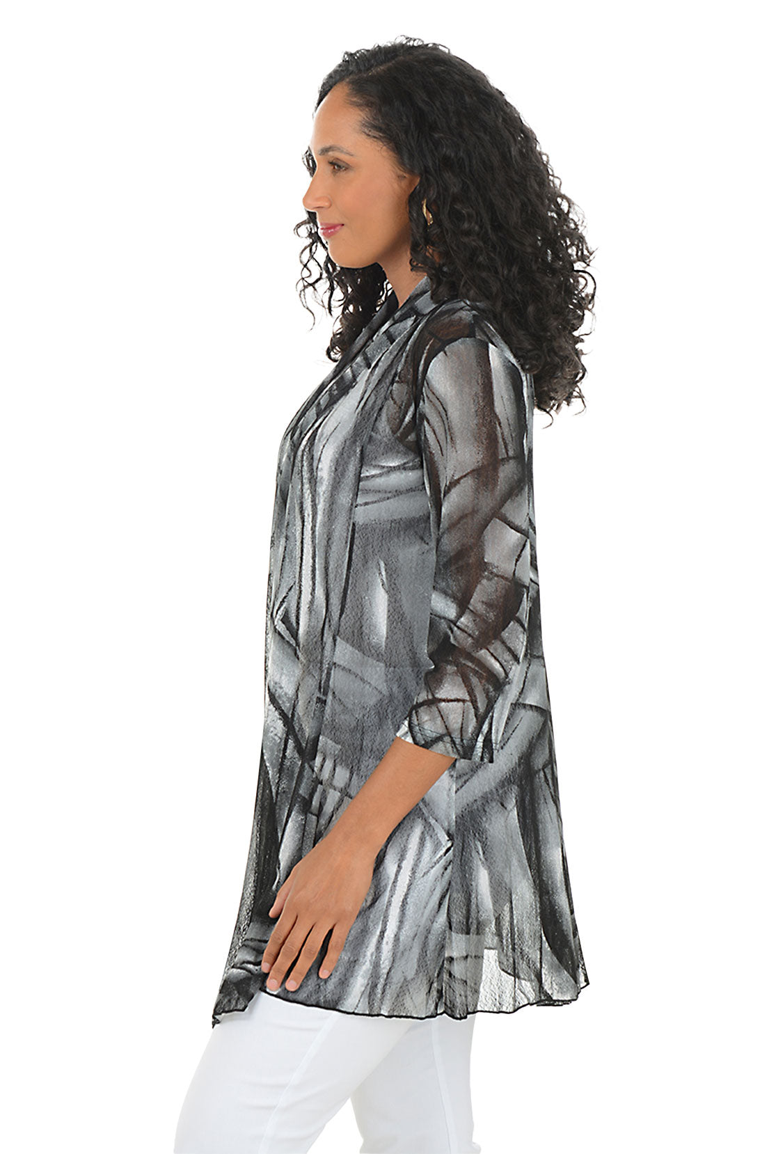 Woman wearing a black and gray patterned cardigan on a white background. Side shot.