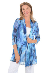 Woman wearing a blue patterned cardigan on a white background.